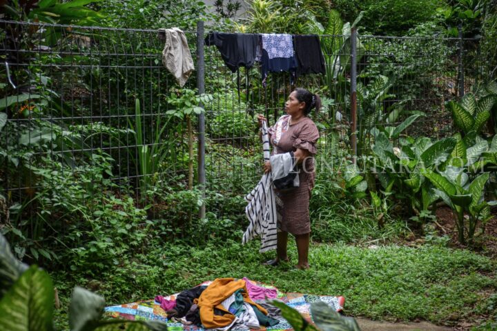 Berneci Samade saat mengangkat pakaian yang dijemur di pagar RSUP. Prof. Kandou, (Foto: Yegar Sahaduta).